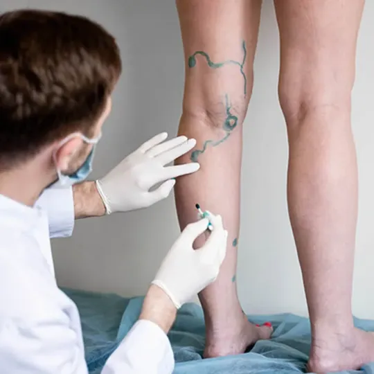 Médico vascular examinando as pernas de um paciente