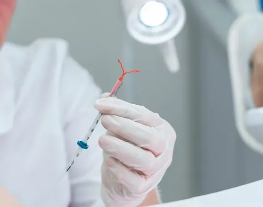 Médica segurando um dispositivo intrauterino (DIU)